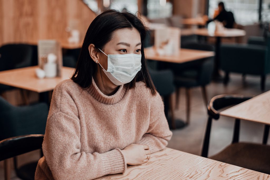Woman wearing protective mask in cafe